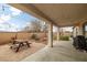 A covered patio features a picnic table and fire pit perfect for outdoor gatherings and relaxation at 1131 S Blagg Rd, Pahrump, NV 89048