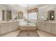 Bathroom featuring a soaking tub, dual vanities, and decorative mirrors at 1303 Panini Dr, Henderson, NV 89052