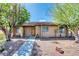 Charming single-story home featuring a well-maintained yard with mature trees and a brick accent wall at 1501 Living Desert Dr # A, Las Vegas, NV 89119