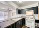 Functional kitchen with dark cabinetry, gas range, breakfast bar, and view to the outdoor space at 1501 Living Desert Dr # A, Las Vegas, NV 89119