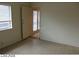 A living room with neutral colored walls, tile flooring, one window, and a view of a door to the outside at 1617 Joshua Tree Ct, Las Vegas, NV 89108