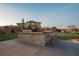 This outdoor kitchen features a built-in barbecue, stone countertops, and seating for outdoor entertaining at 18 Garden Rain Dr, Las Vegas, NV 89135