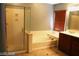Bright bathroom featuring a walk-in shower, bathtub, and wooden blinds at 1837 Ardilea St, Las Vegas, NV 89135