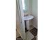 Powder room with pedestal sink, round mirror and tile flooring at 1837 Ardilea St, Las Vegas, NV 89135