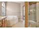Bright bathroom featuring double vanity, soaking tub, glass enclosed shower and tile flooring at 2197 Big Bar Dr, Henderson, NV 89052