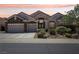 Inviting single-story home with a three car garage, desert landscape, and manicured front yard at 2197 Big Bar Dr, Henderson, NV 89052