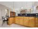 Spacious kitchen featuring wood cabinets, granite countertops, and an eat-in breakfast bar at 2197 Big Bar Dr, Henderson, NV 89052