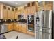 Bright kitchen with stainless steel appliances, tile floors, and attractive wooden cabinets at 2197 Big Bar Dr, Henderson, NV 89052
