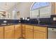 Charming kitchen features custom cabinets, black countertops and mosaic backsplash at 2197 Big Bar Dr, Henderson, NV 89052