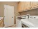 Functional laundry room with cabinets, sink, and modern washer and dryer units at 2197 Big Bar Dr, Henderson, NV 89052