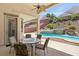 Inviting covered patio with seating overlooking a waterfall pool at 2197 Big Bar Dr, Henderson, NV 89052