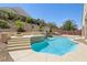 Beautiful pool area featuring a rock waterfall, tanning ledge, and steps up to fire pit at 2197 Big Bar Dr, Henderson, NV 89052