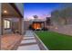 Inviting backyard with pavers, a pergola covered seating area with a fire pit, and lush artificial turf at 2367 Ridgeline Wash St, Las Vegas, NV 89138