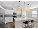 Open kitchen featuring a stainless steel refrigerator, white cabinetry, and an island with bar stool seating at 2367 Ridgeline Wash St, Las Vegas, NV 89138