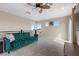 Comfortable living room with a plush green sofa, ceiling fan, and balcony access with bright view at 2367 Ridgeline Wash St, Las Vegas, NV 89138