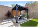Charming outdoor patio area featuring a black pergola, comfortable seating, and xeriscaping at 2367 Ridgeline Wash St, Las Vegas, NV 89138