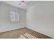 Minimalist bedroom featuring neutral walls, plush carpet, and natural light from the window at 2470 Lothian St, Henderson, NV 89044