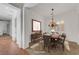 Elegant dining room with a chandelier, a wooden table set for six, and plantation shutters at 2470 Lothian St, Henderson, NV 89044