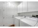 Functional laundry room featuring white cabinets, washer, and dryer for convenience at 2470 Lothian St, Henderson, NV 89044