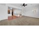 Spacious living room featuring neutral carpet, a ceiling fan, and abundant natural light from the windows at 2470 Lothian St, Henderson, NV 89044