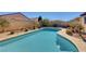 Sparkling blue in-ground pool, surrounded by concrete patio and desert landscaping in the backyard at 2470 Lothian St, Henderson, NV 89044