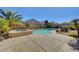 Backyard pool and spa surrounded by a concrete patio and lush landscaping, including palm trees and shrubs at 2470 Lothian St, Henderson, NV 89044