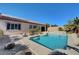 Stunning pool area with clear blue water, surrounded by desert landscaping, and a view of the home's exterior at 2470 Lothian St, Henderson, NV 89044