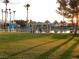 Picturesque lake view with picnic area, blue canopies, and lounge chairs surrounded by green grass at 2636 Ontario Dr, Las Vegas, NV 89128