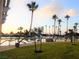 Scenic view of a lake with palm trees, a sandy beach, and lounge chairs under a beautiful sunset sky at 2636 Ontario Dr, Las Vegas, NV 89128