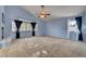 Spacious living room featuring large windows, high ceilings, carpet floors, and a ceiling fan at 2636 Ontario Dr, Las Vegas, NV 89128