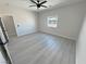 Bright bedroom featuring gray floors, ceiling fan, and natural light through a large window at 2900 W Jaybird St, Pahrump, NV 89048