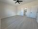 Spacious bedroom featuring gray floors, ceiling fan, and access to closet and bathroom at 2900 W Jaybird St, Pahrump, NV 89048