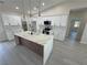 Bright, modern kitchen with a kitchen island, stainless steel appliances, and white cabinets at 2900 W Jaybird St, Pahrump, NV 89048