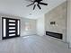 Modern living room with a fireplace, wood-style floors, and a modern front door at 2900 W Jaybird St, Pahrump, NV 89048
