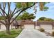 Charming townhome featuring a well-maintained lawn, mature trees, and a two-car garage at 2935 Pinehurst Dr, Las Vegas, NV 89109