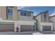 Contemporary-style home exterior featuring neutral stucco, brown garage doors, and mint accents under a blue sky at 3359 Via Tizzoni St, Henderson, NV 89044