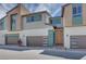 Modern townhome featuring a three-car garage with stylish doors, accented by contemporary color schemes and clean lines at 3359 Via Tizzoni St, Henderson, NV 89044