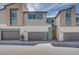 Contemporary townhome showcasing modern design elements, a three-car garage, and a welcoming entryway with stylish front door at 3359 Via Tizzoni St, Henderson, NV 89044
