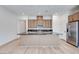 Modern kitchen showcasing a center island with granite countertops, stainless steel appliances, and light wood flooring at 3359 Via Tizzoni St, Henderson, NV 89044