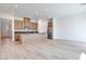 Open-concept kitchen with wood cabinets, stainless steel appliances, a center island, and light wood flooring at 3359 Via Tizzoni St, Henderson, NV 89044