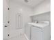 Functional laundry room featuring white washer and dryer, complemented by white shelving and neutral walls at 3359 Via Tizzoni St, Henderson, NV 89044