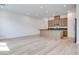 Spacious open-concept area with kitchen, island, stainless appliances, and light wood flooring at 3359 Via Tizzoni St, Henderson, NV 89044