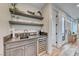 Elegant wet bar featuring gray cabinetry, stone countertops, open shelving, and a wine fridge at 365 Crown Mesa Ave, Las Vegas, NV 89138