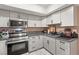 Kitchen boasts stainless steel appliances, grey cabinets, and updated lighting at 3774 Decade St, Las Vegas, NV 89121