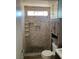 Renovated shower with tiled surround, stone floor, and recessed shelving at 4454 Bertram Ln, Las Vegas, NV 89147