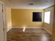 Bright bedroom with wood-look flooring, two windows providing ample natural light, and neutral wall color at 4454 Bertram Ln, Las Vegas, NV 89147