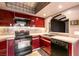 Modern kitchen featuring sleek red cabinets, up-to-date appliances and a practical pass-through window at 4742 Obannon Dr # D, Las Vegas, NV 89102