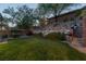 Beautiful backyard with lush lawn, mature trees, and a stone retaining wall, creating a serene outdoor space at 48 Panorama Crest Ave, Las Vegas, NV 89135
