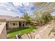 Expansive backyard with lush lawn, covered patio, and desert landscaping, creating a private outdoor oasis at 48 Panorama Crest Ave, Las Vegas, NV 89135