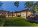 Beautiful backyard featuring lush lawn, covered patio, outdoor kitchen, and stone accents at 48 Panorama Crest Ave, Las Vegas, NV 89135